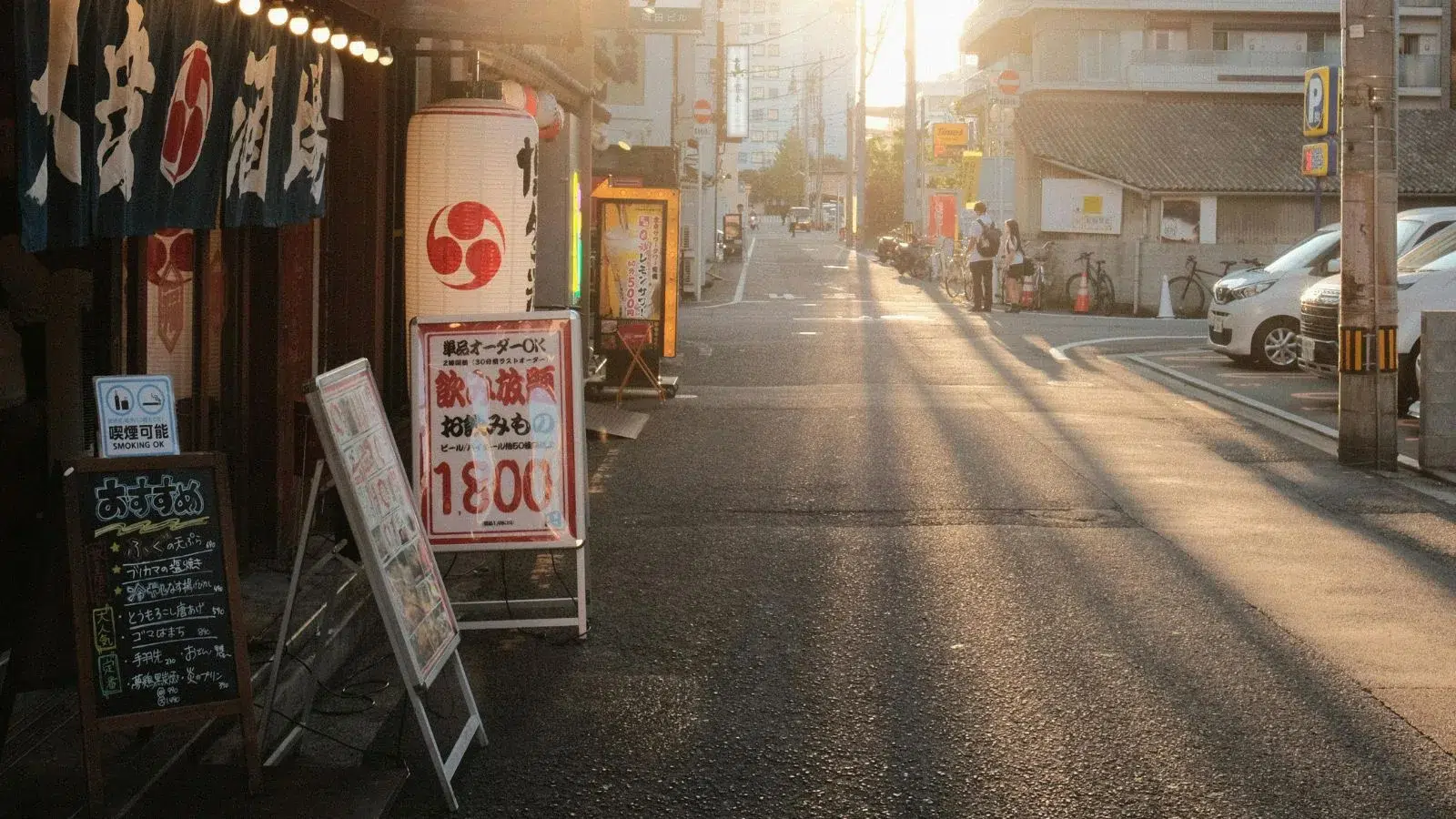 شارع هادئ في إحدى المدن اليابانية مع متاجر محلية ولافتات يابانية، يرمز للحياة اليومية للمقيمين في اليابان.