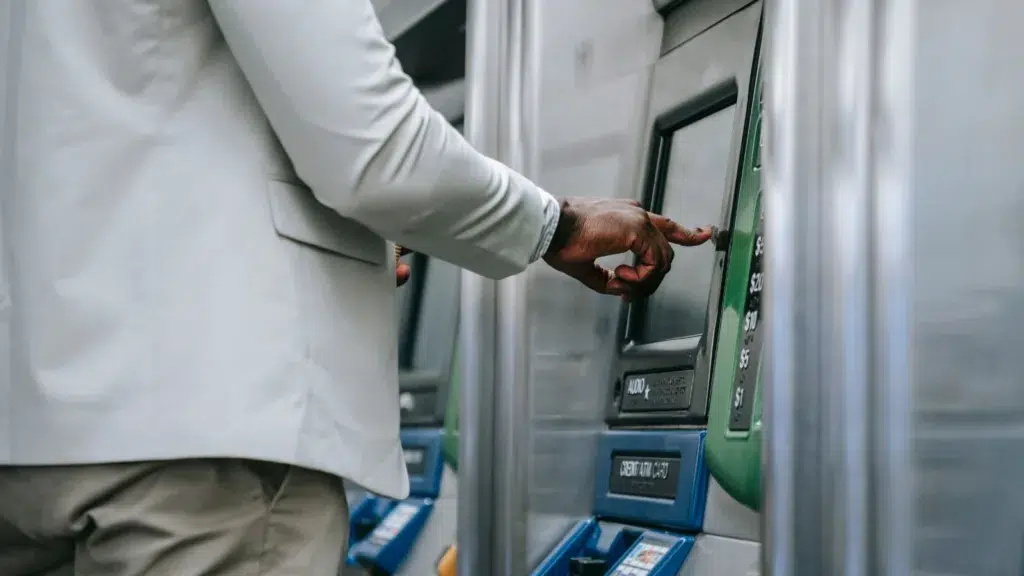 شخص يستخدم جهاز صراف آلي لسحب المال، يرمز إلى الرواتب والدخل في الدول الأوروبية.